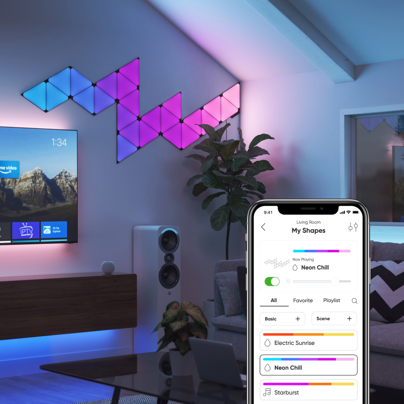 Nanoleaf Shapes Thread enabled color changing black triangle smart modular light panels mounted to a wall in a living room. Nanoleaf App. Similar to Philips Hue, Lifx. HomeKit, Google Assistant, Amazon Alexa, IFTTT.