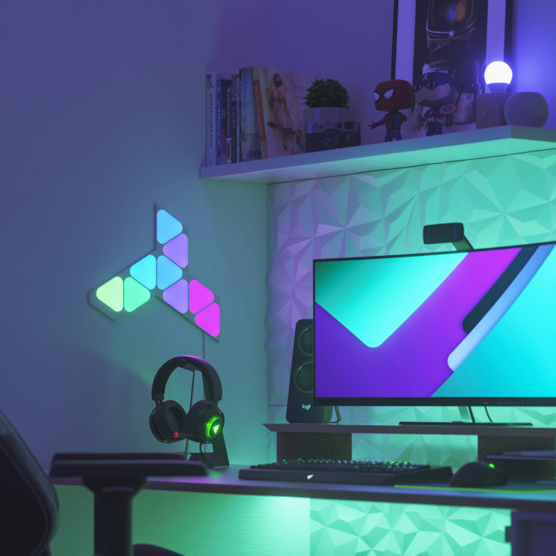 PC gaming setup with 9 Nanoleaf Shapes Mini Triangle light panels mounted on the wall beside the monitor. The best gaming lights for playing PC games.